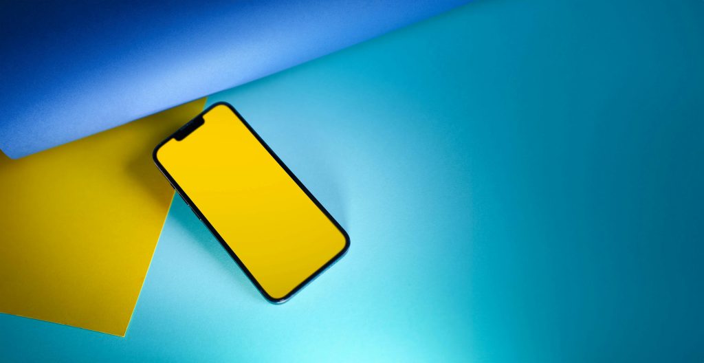 pexels-photo-17571892-17571892 Stylish smartphone with a yellow screen on blue and yellow paper, ideal for tech and design concepts.