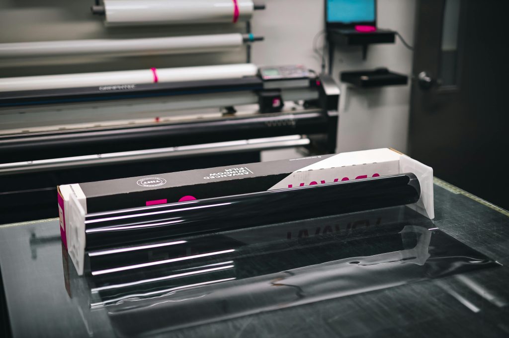 A glossy roll of vinyl material inside a modern print shop, ready for use in creating projects.